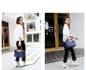 Detail view of navy nylon tote bag with leather handles and detachable shoulder strap