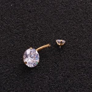 Golden belly button ring with round clear zircon crystals on black textured background