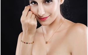 Dettaglio del bracciale in oro rosa con zirconi arcobaleno e collana con ciondolo tondo