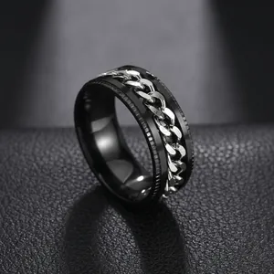 Detail of black stainless steel spinning ring featuring an inlaid silver curb chain