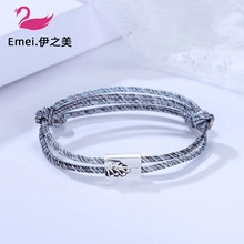 Detailed view of multilayer woven bracelet with silver metal clasp and leaf engraving