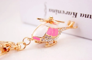 Macro view of helicopter keychain with pink enamel and sparkling white rhinestones