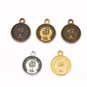 Detail showing vintage zinc alloy coin pendants with embossed queen portraits in five metal finishes