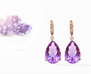 Macro view of rose gold pear-cut amethyst earrings with lavender floral detail
