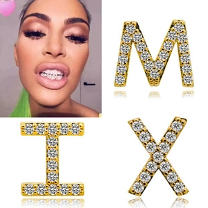 Detailed macro view of 18K gold plated hip hop grillz with iced out zircon letter charms