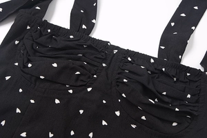 Detail des gerafften schwarzen Tops mit weißem Herzmuster und zarten Trägern