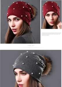 Detail of double-layer knit beanie featuring pearls, rhinestones and large fur pom-pom
