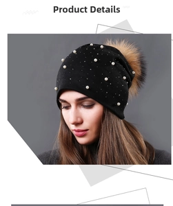 Close-up of black double-layer knit beanie with white pearls and large faux fur pom-pom