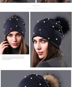 Close-up of navy blue winter beanie with elegant pearls, rhinestones and fluffy pom-pom