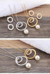 Detailed close-up of intertwining geometric rings with rhinestones and white pearl drops