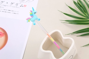 Detail of cute unicorn stationery pen with rainbow gradient ink and silicone topper