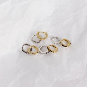 Macro detail of eight S925 silver hoop earrings with cubic zirconia on white background
