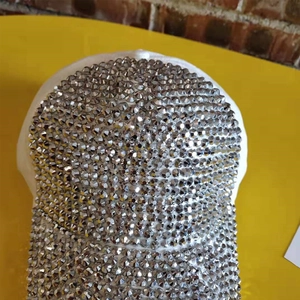 Close-up of sparkling silver rhinestones on a white baseball cap with metallic luster
