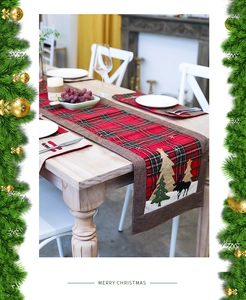 Detailed embroidery of reindeer and Christmas tree on red plaid linen festive table runner