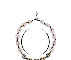 Detail of adjustable black cord shell necklace with gold-toned shells and white pearls