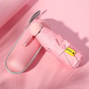 Pink mini folding umbrella with UPF50+ sun protection and matching capsule storage case