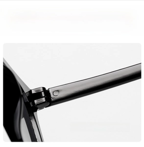 Macro shot of durable metal hinge on black oversized sunglasses with white text detail