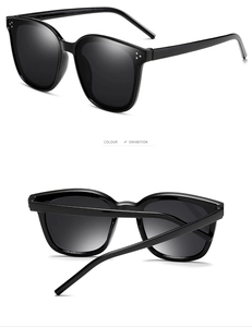 Detail showing oversized black square sunglasses with three metal dots on the frame