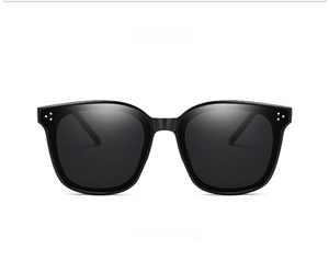 Close-up of black square sunglasses with three silver metal rivets on the side frame