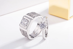 Detailed close-up of diamond couple rings featuring Greek patterns and crown settings