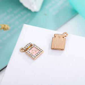 Macro view of perfume bottle charm with pink enamel, white rhinestones, and N°5 engraving
