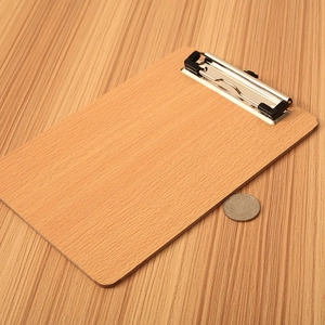 Minimalist A4 wooden clipboard with silver metal clip on a textured wood surface