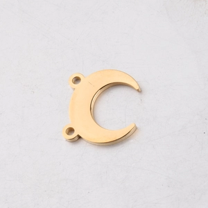 Close-up of golden crescent moon connector for DIY jewelry making with dual holes