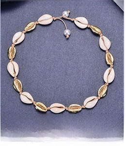 Detail of bohemian handmade braided choker with natural white shells and gold alloy shells