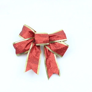 Sparkling red Christmas bow with gold glitter edges for tree decoration and gift wrapping