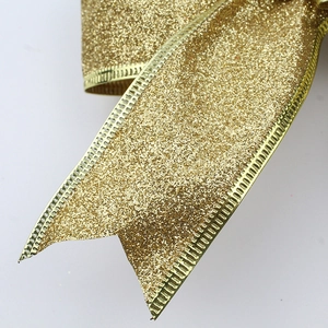 Macro detail of Christmas bow featuring golden glitter texture and metallic serrated edges