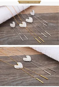 Detail view of heart-shaped diamond tassels earrings in gold and silver finishes