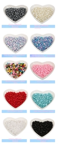 Mix of colorful faux pearls in heart-shaped bowls for DIY jewelry and crafts decorations