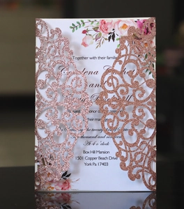 Detail of laser-cut rose gold glitter wedding invitation with elegant floral insert