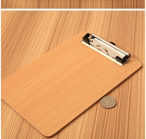 Macro detail of wooden clipboard with silver metal clip and black anti-slip pads