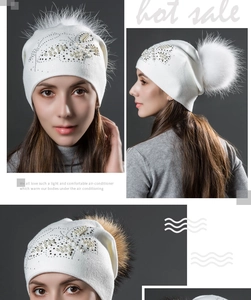 Détail du bonnet en tricot ivoire avec papillon en perles et pompon en fourrure douce