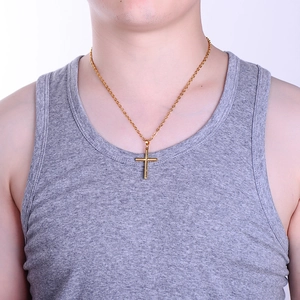 Polished gold cylindrical cross pendant necklace for women on a model with classic chain