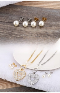 Macro detail of heart-shaped zircon pearl necklaces and earrings in high-polished finish
