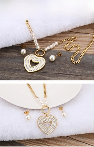 Close-up of heart pendant necklace with rhinestones and matching pearl earrings