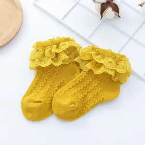 Detailed close-up of yellow baby princess socks with double-layered lace ruffles