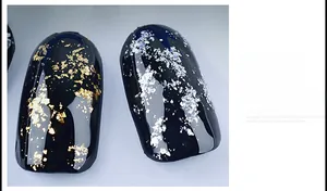 Vue détaillée de faux ongles noirs avec des éclats de feuilles d'or et d'argent