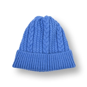 Close-up of blue cable knit beanie showing thick texture and wide ribbed cuff detail