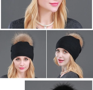 Dettaglio del berretto in maglia nera con grande pompon di pelliccia sintetica per donne