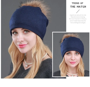 Vista dettagliata di un berretto in lana blu navy da donna con pompon in vera pelliccia