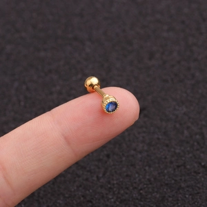 Close-up of gold screw-back stud earring with a round blue cubic zirconia gem