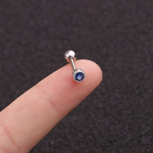 Macro detail of silver stainless steel stud earring with a blue round cubic zirconia stone