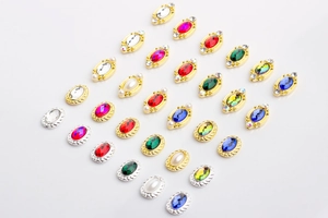 Detailed grid of oval alloy nail charms with colorful gemstones and pearl accents