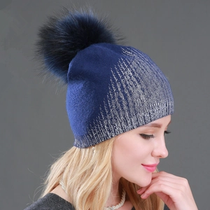 Navy blue winter knitted hat with silver glitter gradient and large faux fur pom-pom topper