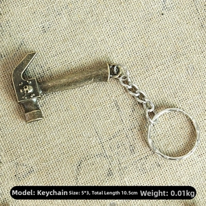 Detail of vintage bronze claw hammer keychain with skull emblem on textured linen background