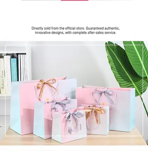Detailed set of gradient pink and blue paper gift bags with silk bow handles and gold foil