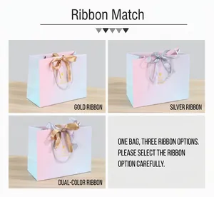 Detail of gradient gift bags showing gold and silver ribbon handle options on wood surface